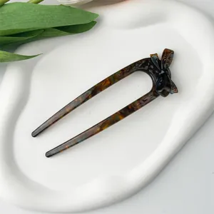 Detail view of U-shaped tortoiseshell acetate hair fork with a classic bow decoration