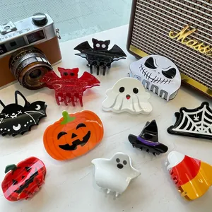 Flat lay of festive Halloween acrylic hair claws with pumpkin, bat and ghost motifs