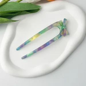 Detail of a marble acetate U-shaped hair fork with a bow knot on a display tray