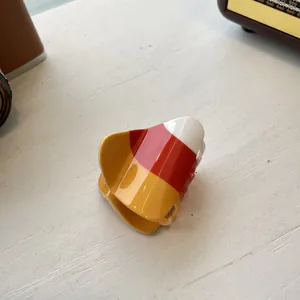 Close-up of candy corn acrylic hair claw with white, orange and yellow polished layers