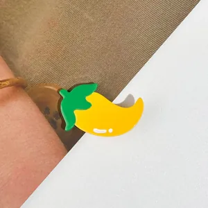 Détail de la pince à cheveux mangue en acétate jaune vif avec petite feuille verte
