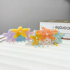 Colorful starfish hair claws with pearls and rhinestones on a white display board