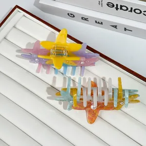 Colorful starfish hair claws with pearls and rhinestones on a white display tray