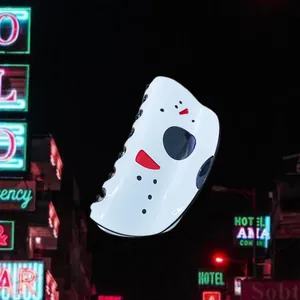 Close-up of white hockey mask horror hair claw with red accents against neon background