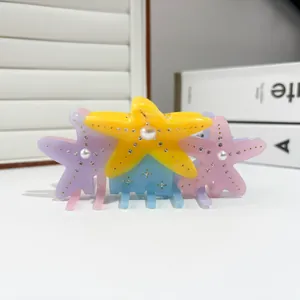 Detailed close-up of colorful starfish hair claws with pearls and small rhinestones