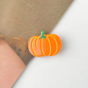 Vue détaillée d'une pince à cheveux citrouille orange en acétate avec détails de tige verte