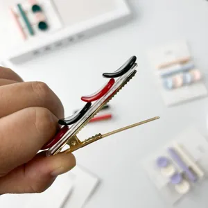 Elegant gold metal alligator hair clip with red and black resin accents for women