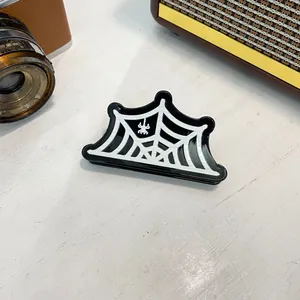 Close-up of black and white spider web acrylic hair claw with a small spider detail