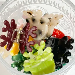 Kleine Haarklammern in Geweihform aus Acetat in verschiedenen Farben in Glasschale