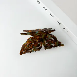 Detailed close-up of butterfly acetate claw clip with blue and tortoiseshell pattern