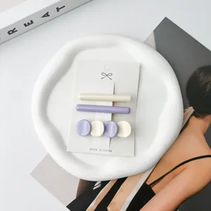 Detailed view of purple and beige acetate hair clips set on a stylish display card