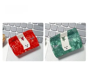 Detail of dollar bill pattern acetate hair claw clip in marble textured red and green