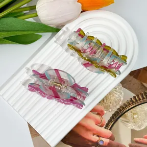 Molle per capelli in acetato colorato con strisce pastello su vassoio elegante