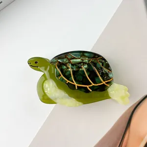 Vue détaillée de la pince à cheveux tortue avec texture agate verte et veines dorées