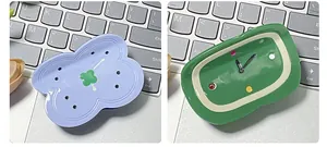 Detail view of clock pattern acetate hair claw clips on a laptop keyboard background