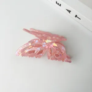 Detailed view of iridescent pink butterfly hair claw clip with a hollow design