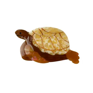 Pince à cheveux tortue en acétate ambré avec des motifs de carapace dorés élégants