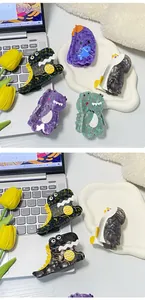 Macro detail of cartoon acetate dinosaur and penguin hair claws with marble texture