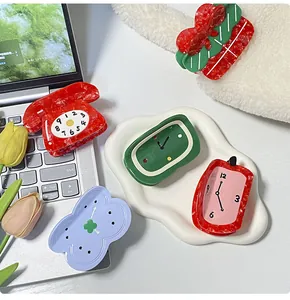 Close-up of creative acetate hair claws in vintage telephone and clock shapes