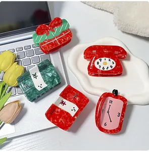 Detailed shot of creative alarm clock and phone shaped acetate hair claws with marble texture