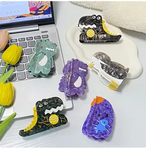 Detail view of cute cartoon acetate hair claws including dinosaur and penguin shapes