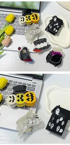 Detail shot of Halloween hair claws featuring pumpkin and ghost icons on a laptop surface