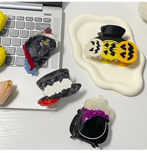 Macro detail of Halloween hair claws featuring pumpkin, pirate hat, and witch cauldron