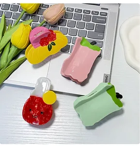 Detail of colorful acetate hair claws featuring floral and smiley face designs