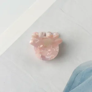 Makro-Detail der Haarklammer mit rosa Marmormuster aus Acetat und glänzender Textur