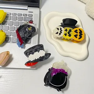 Set of four Halloween hair clips featuring pumpkin, ghost, and witch cauldron designs