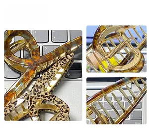 Detailed view of acetate hair claw clips with tortoiseshell pattern and gold metal spring