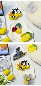 Vista dettagliata di mollette per capelli in acetato con motivi ad ape, farfalla e frutta