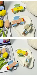 Dettaglio di mollette per capelli a forma di matita con strass in acetato colorato