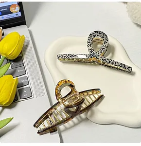 Close-up of elegant leopard print and amber hair claws on a wavy ceramic tray with tulips