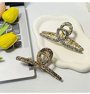 Detail of leopard print acetate hair claws in brown and white on a desktop tray