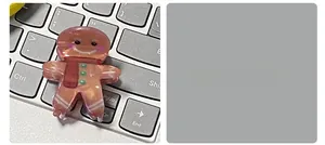 Détail d'une pince à cheveux bonhomme de pain d'épices avec écharpe sur un clavier