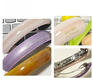 Detail showing acetate hair clip set with spring metal buckle and French logo branding