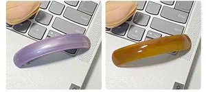 Detail view of tortoiseshell and purple resin hair clips on a laptop keyboard