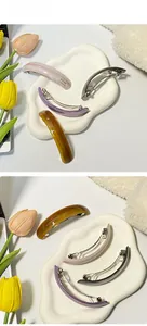 Detail view of colorful glossy arc barrettes in amber, lilac, pink and grey finishes