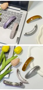 Detailed close-up of marble pattern acetate hair clips on a silver laptop surface