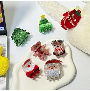 Gros plan de pinces à cheveux sapin de Noël et Père Noël sur un plateau en céramique