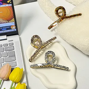 Three acetate hair claws with animal patterns in leopard, tortoiseshell, and dot designs