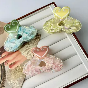 Elegant rhinestone heart hair claws in pink, yellow and cyan with marble texture