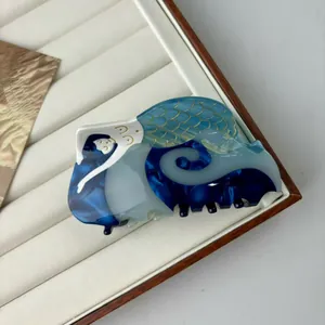 Elegant mermaid hair claw clip with blue marble texture and gold scales on white box