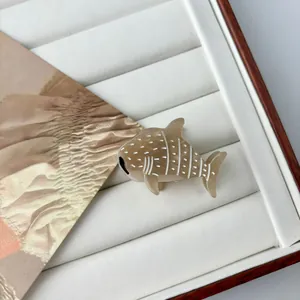 Detailed view of a mini whale shark hair claw clip made of brown acetate fiber material