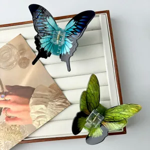 Elegant butterfly hair claws in green and blue gradient acetate with a spring clip design
