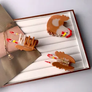 Cute acetate rooster hair claw clips in brown and white with detailed red comb accents