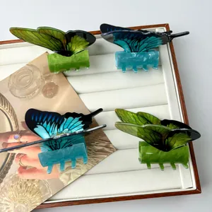 Elegant green and blue butterfly hair claws set on a white display tray