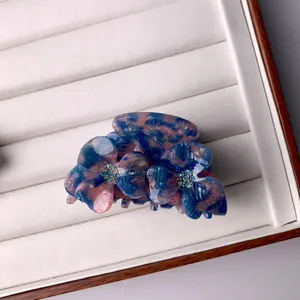 Pince à cheveux fleur élégante avec motif marbré bleu et rose et détails en strass