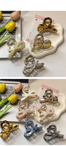 Medium acetate hair claws in various patterns like tortoiseshell and marble on a desk